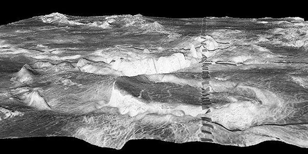 Der kreisrunde Berg im Vordergrund ist eine 500 Kilometer große Corona in der Galindo-​Region der Venus. Die dunklen Rechtecke sind ein Artefakt. Copyright: NASA/JPL/USGS