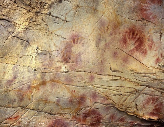 Handabdrücke in der Höhle El Castillo in Spanien gehören zu den ältesten Beispielen europäischer Höhlenkunst. Die rot-ockerfarbenen Handabdrücke sind ein weltweit verbreitetes Motiv - und könnten als Reaktion auf globale Klimaveränderungen in Folge eines stillgelegten Magnetfeldes hindeuten. Copyright: Paul Pettitt, Gobierno de Cantabria