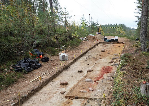 Die roter Ocker-Verfärbung des Bodens weist das Grab des Steinzeitkindes aus. Copyright: Kirkinen Mannermaa