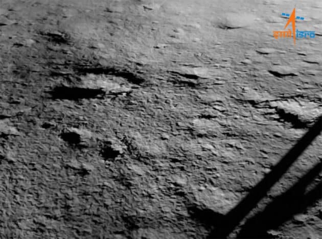 Die erste Bodenaufnahme einer der Kameras des indischen Mondlandemoduls der Mission „Chandrayaan-3“ am Südpol des Mondes. Deutlich zu sehen auch das Landebein samt Schatten. Copyright: ISRO