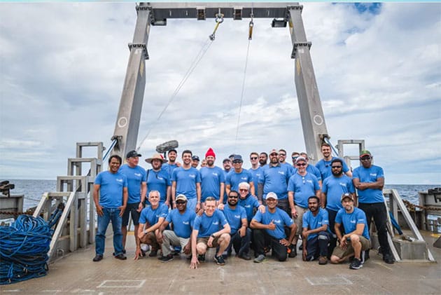 Das Expeditionsteam auf dem Deck des Schiffes "Silver Star" (27. Juni 2023). Der große A-Rahmen im Hintergrund lenkte ein langes Kabel vom Schiff zu dem magnetischen Schlitten am Meeresboden in einer Tiefe von 2 Kilometern. Der Schlitten holte etwa 700 submillimetergroße Sphärulen durch 26 Durchläufe zurück, die eine 10 Kilometer große Region um den Feuerball-Ort des ersten erkannten interstellaren Meteoriten, IM1, kreuz und quer durchquerten.Copyright/Quelle: Avi Loeb
