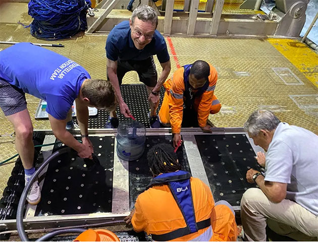 Ryan Weed (links) saugt den Magneten des Schlittens ab und trägt dabei das T-Shirt des "Interstellar Expedition Teams".Copyright/Quelle: Avi Loeb