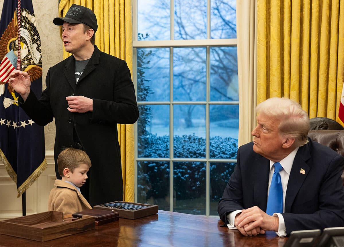Symbolbild: Elon Musk referiert am 11. Februar 2025 mit MAGA-Cap und Sohn vor US-Präsident Trump im Oval Office des White House.Copyright: The White House