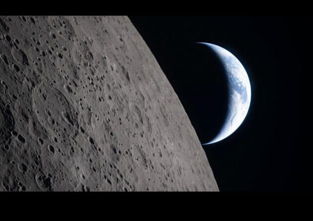 Am 6. April 2026 fotografierte die Artemis-2-Crew die Erdsichel. Während Australien und Ozeanien noch sonnenbeschienen sind, liegt der Rest des sichtbaren Globus bereits im Nachtschatten. Im Vordergrund zu sehen: Der Ohm-Krater auf der Rückseite des Mondes. Copyright: NASA