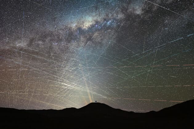 Diese Überlagerung eines einstündigen Zeitraffers vom 15. Oktober 2025 zeigt zahlreiche Satellitenspuren über der Atacama-Wüste in Chile. Im Vordergrund ist die Baustelle des Extremely Large Telescope (ELT) der ESO zu sehen, im Hintergrund die Laser des Paranal-Observatoriums mit dem Very Large Telescope (VLT). Copyright/Quelle: F. Kamphues, ESO/M. Kornmesser