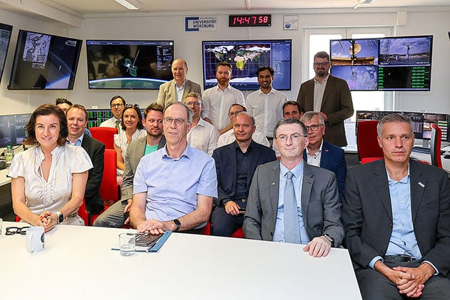 Gruppenbild aus dem Missionskontrollzentrum mit (vorne v.l.): Dorothée Bär, Unipräsident Paul Pauli, Hakan Kayal und Hannes Taubenböck. Rechts hinter der Ministerin ist Marco Schmidt zu sehen.Quelle/Copyright: IFEX/IHK Würzburg-Schweinfurt/Rudi Merkl